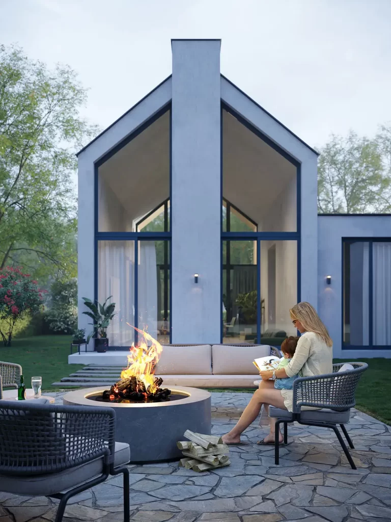 3D render of a modern home exterior with a fire pit, outdoor seating, and a woman reading to a child, by 100CGI Studio.