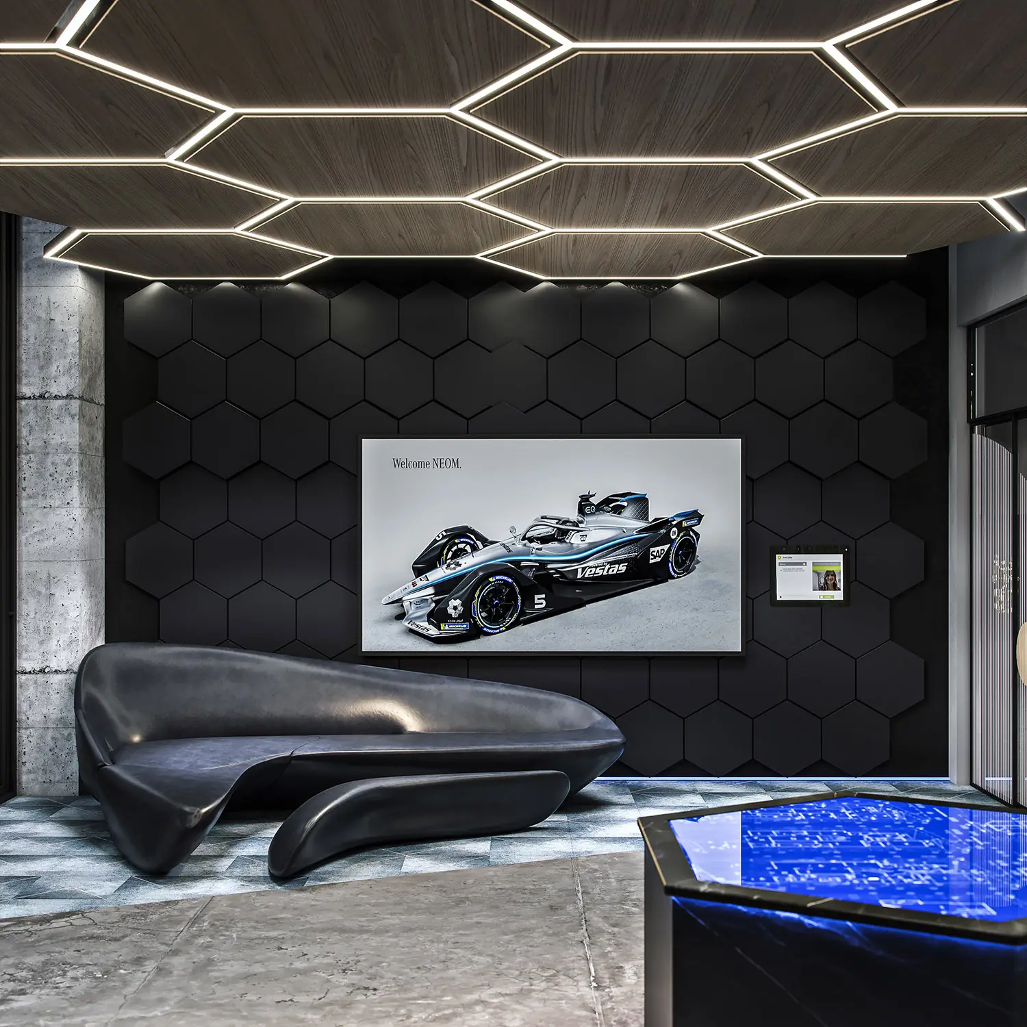 Render of a modern lobby with a futuristic black sofa, hexagonal lights, and a race car display.