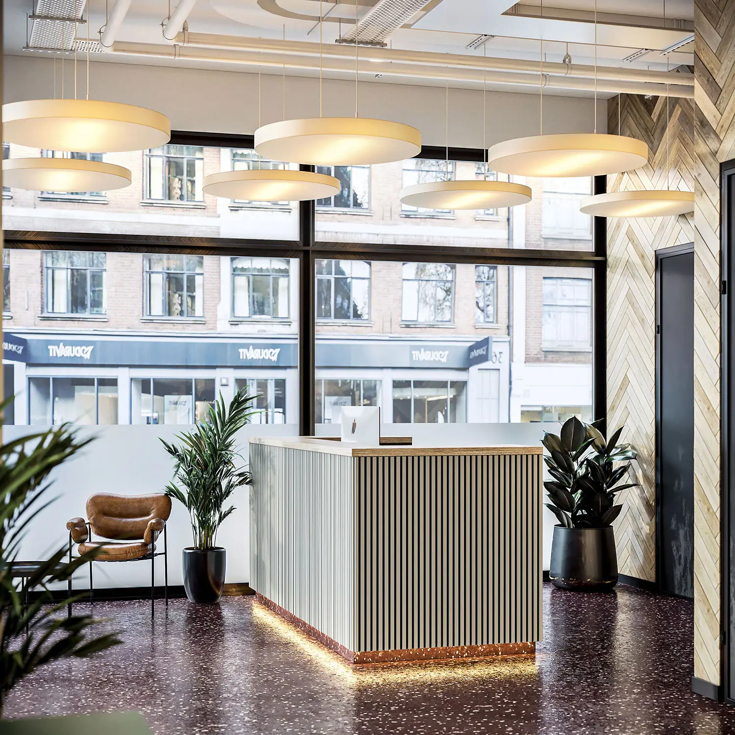 Modern reception area with sleek design, warm lighting, and large windows facing the street.